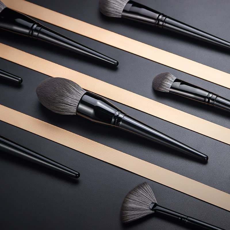 Makeup Brushes Set with black lacquered wooden handles and soft synthetic gray bristles in various shapes and sizes on a dark background.