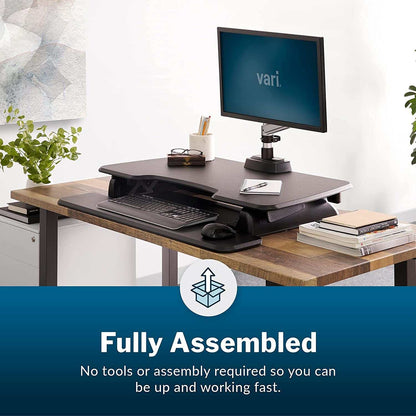 Two-Tier Standing Desk with black finish, dual-handle spring-assisted lift, adjustable height, upper monitor platform and lower keyboard tray.