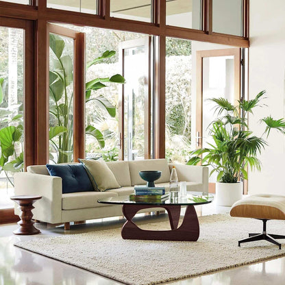 Triangle Glass Coffee Table with clear tempered glass top and sculptural dark walnut solid wood base in modern living room setting
