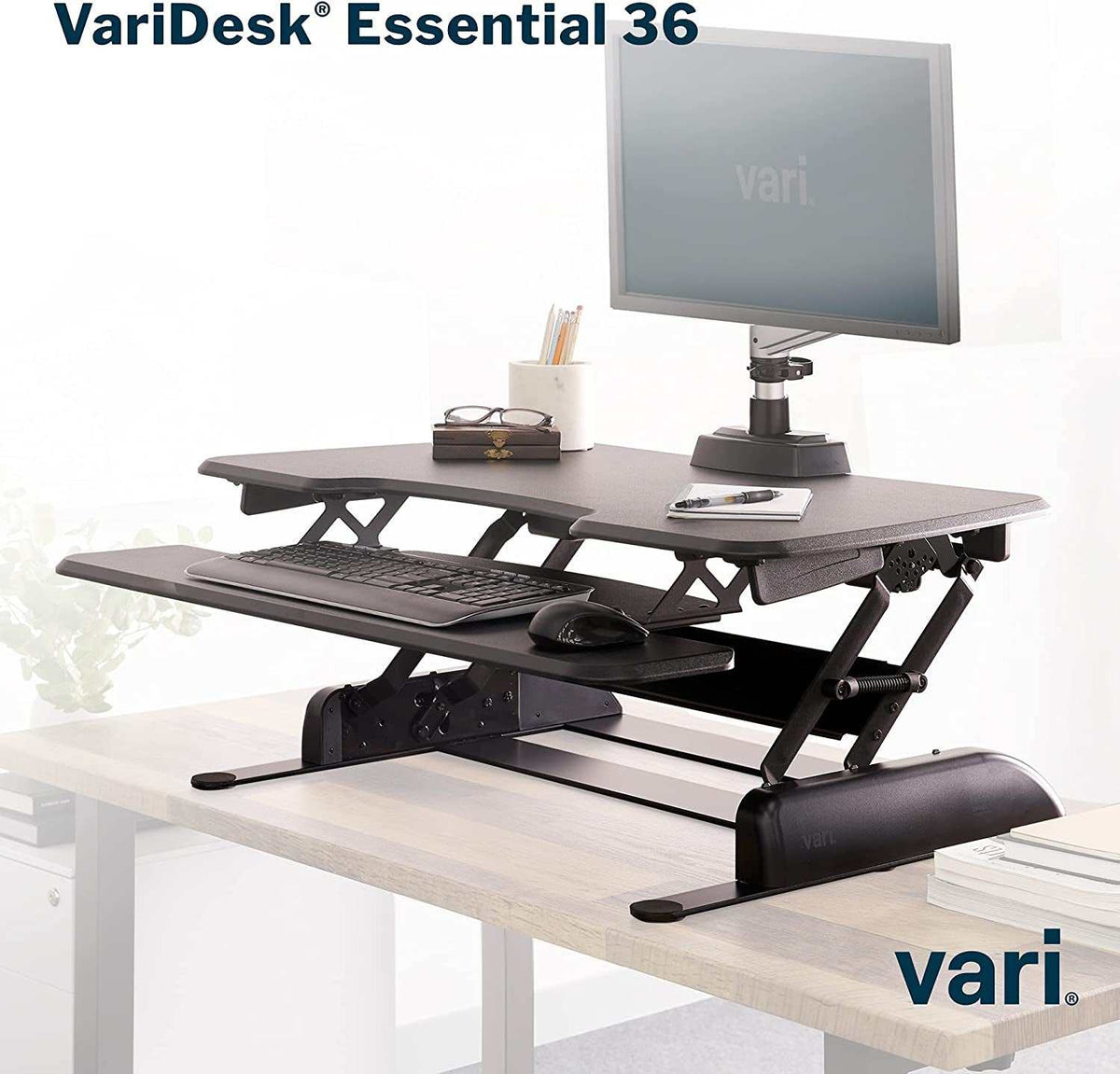 Two-Tier Standing Desk converter in black with adjustable height, featuring a top monitor platform and lower keyboard tray with dual-handle lift.