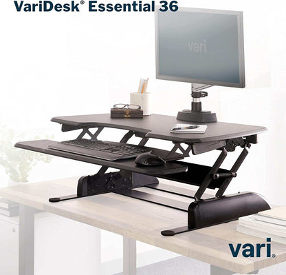 Two-Tier Standing Desk converter in black with adjustable height, featuring a top monitor platform and lower keyboard tray with dual-handle lift.
