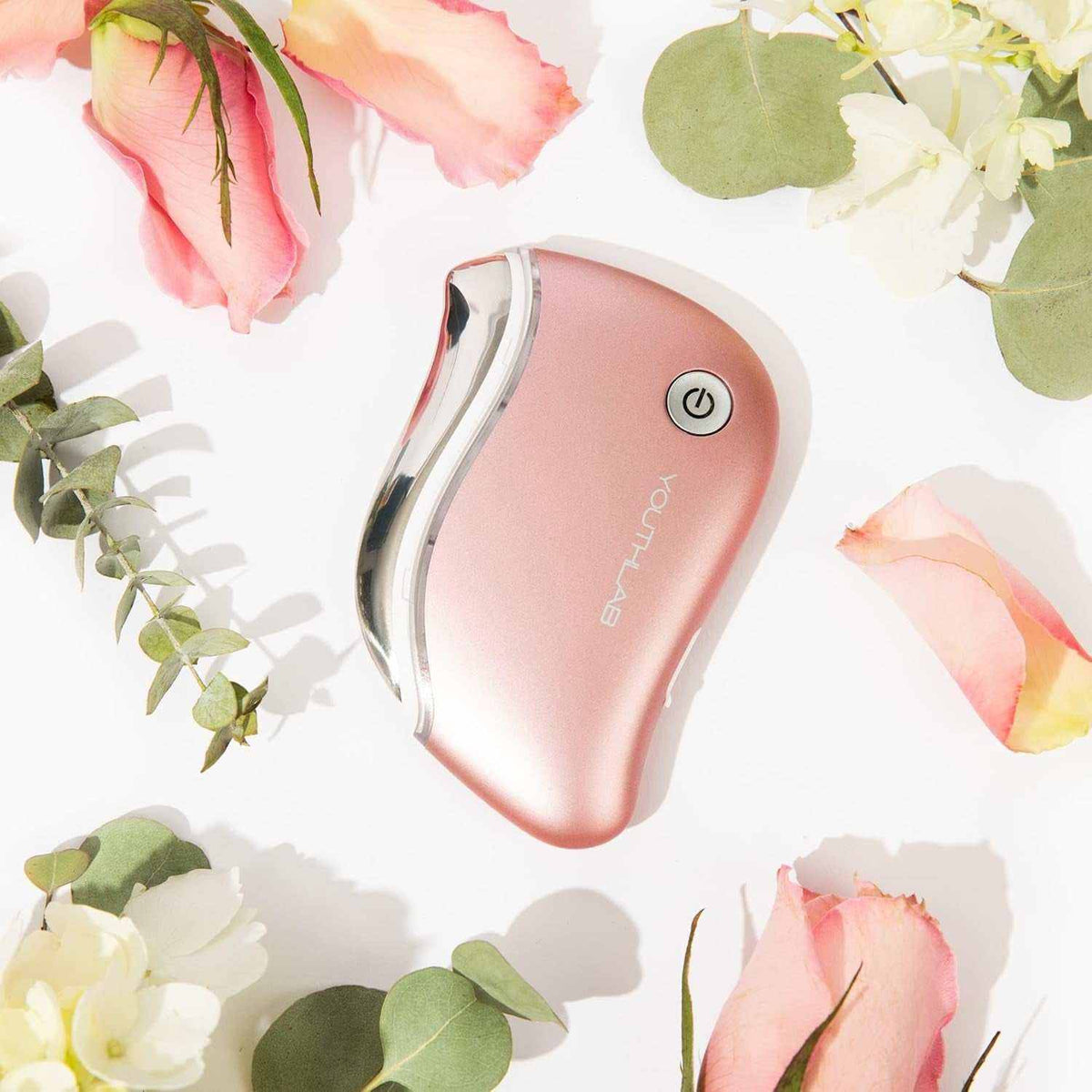 Heated Gua Sha Tool in rose gold with ergonomic contoured design, power button, and metal edges for facial sculpting